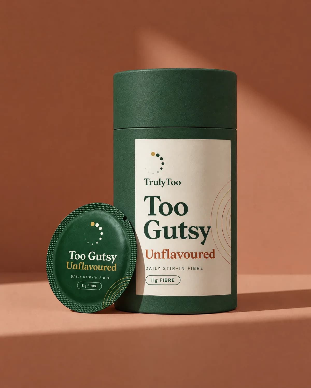 Too Gutsy Unflavoured: a deep green tube with a cream label and a round green sachet leaning beside it